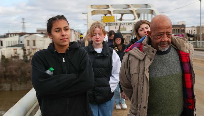 Civil rights activist Charles Mauldin, left, and bet36365体育 sophomore Jamie Vaughn lead a group of political science students across Edmund Pettus Bridge in Selma, Alabama